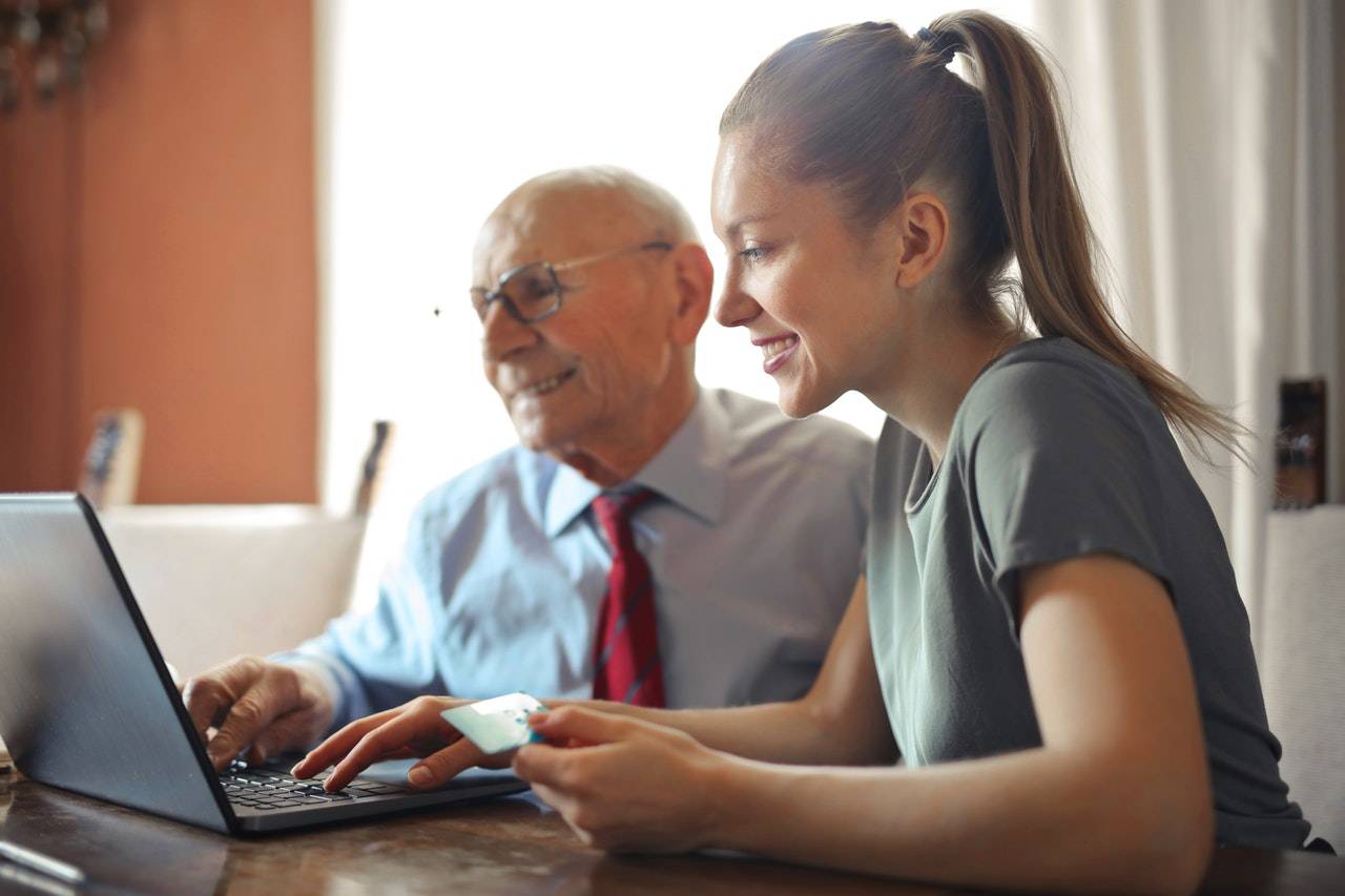An elderly man and young girl using computers - darren yaw singapore